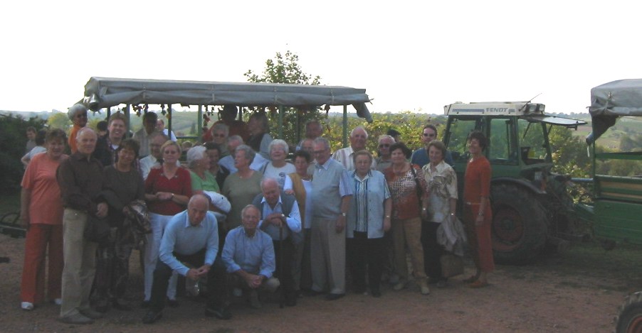 Das Foto zeigt die Reisegruppe aus Schneck vor einem der Planwagen inmitten der Weinberge der Gemeinde Nierstein am Rhein.